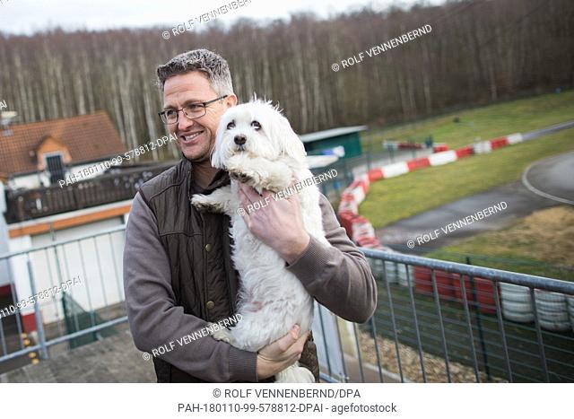Former Formula 1 racer Ralf Schumacher and his dog Jessy standing at the karting track in Kerpen,  Germany, 10 January 2018
