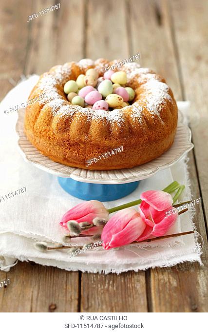 An Easter orange cake decorated with coloured chocolate eggs
