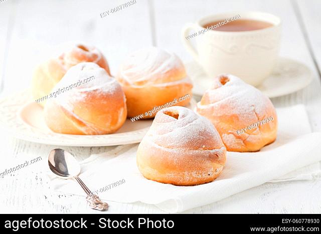 a dish of choux cream with a cup of tea or coffee for an afternoon break