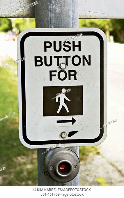 Push button for pedestrian crossing, silhouette person walking, button and sign on metal post, Information signs along highway. Riverwoods. Illinois