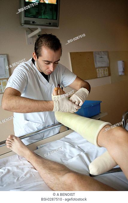 Photo essay from La Croix Saint-Simon Hospital, Paris, France. Department of orthopedics. Placement of a resin plaster by at the physical therapist on a...