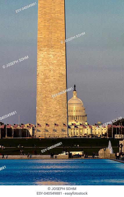 APRIL 8, 2018 WASHINGTON D.C. - US Flags with cropped view of US Capitol and Washington Monument surrounded by visitors to Washington, D.C