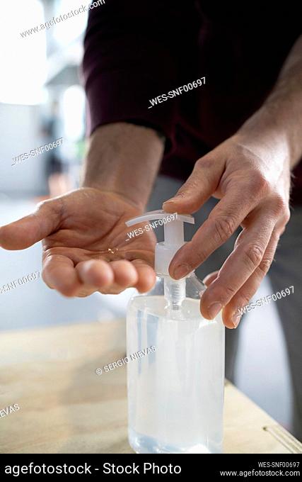 Close-up of man washing hand with sanitizer