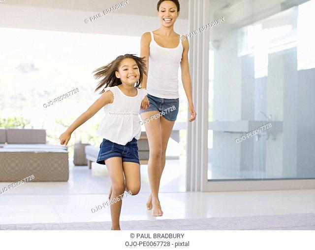 Mother and daughter holding hands and running