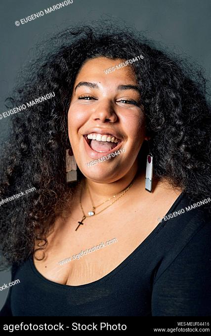 Laughing young woman against gray background