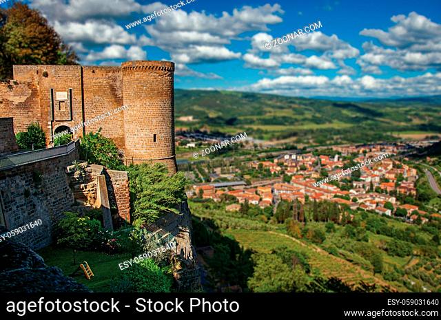 Overview of stone tower, green hill, vineyards and rooftops near a road at the city of Orvieto, an ancient, pleasant and well preserved medieval town