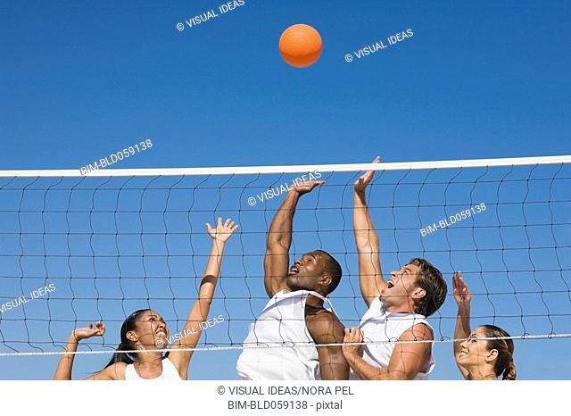 Multi-ethnic friends playing volleyball