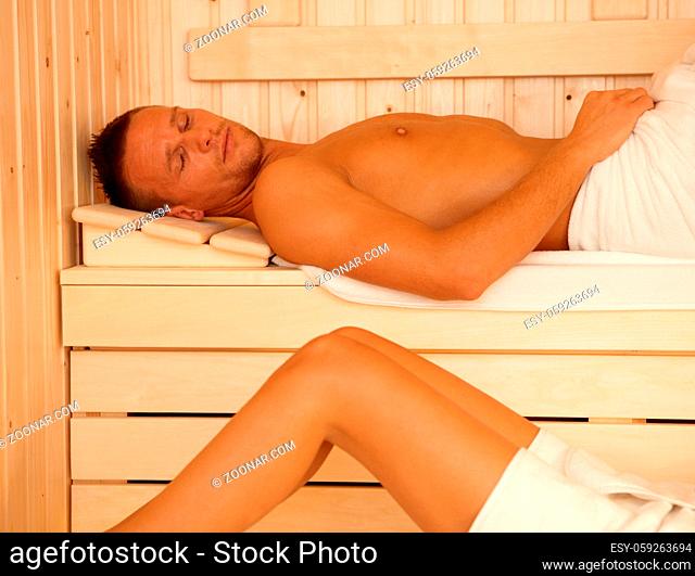 Sauna relaxation, sporty man lying, enjoying healthy heat
