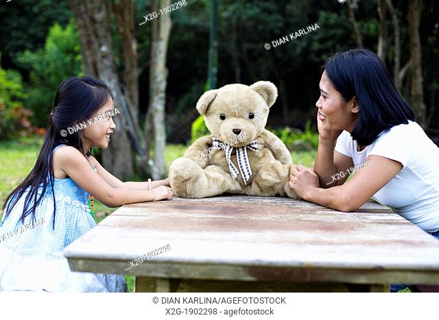 China, Hong Kong, Mother and daughter (8-9) playing in garden