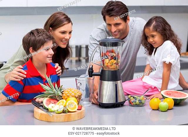 Smiling family using a blender
