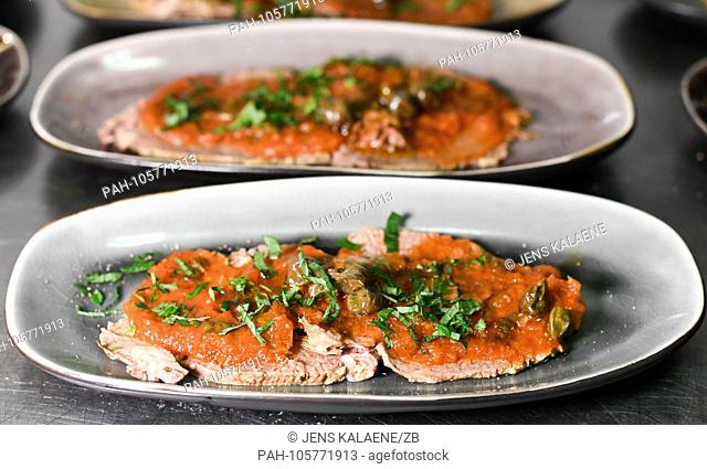 12.06.2018, Linum, Brandenburg: Platters with ""Vitello tomato"" from the Havelland beef with homemade tomato sauce, capers and fresh parsley are in the kitchen...