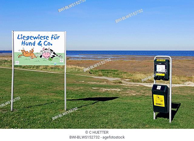 Sign 'lawn for dogs and co' and dispenser with bags for dog faeces, Germany, Lower Saxony, East Frisia, Dornumersiel