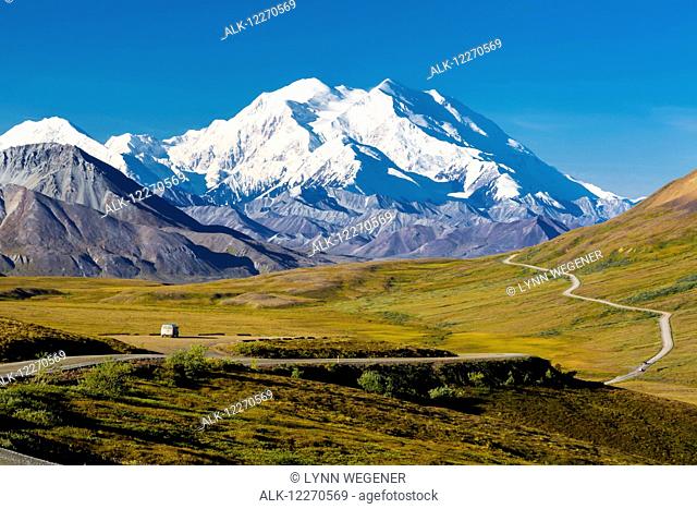 Scenic view of Mt. McKinley, Thorofare Pass, and Stony Dome in the foreground with a vehicle on the park road, Denali National Park, Interior Alaska