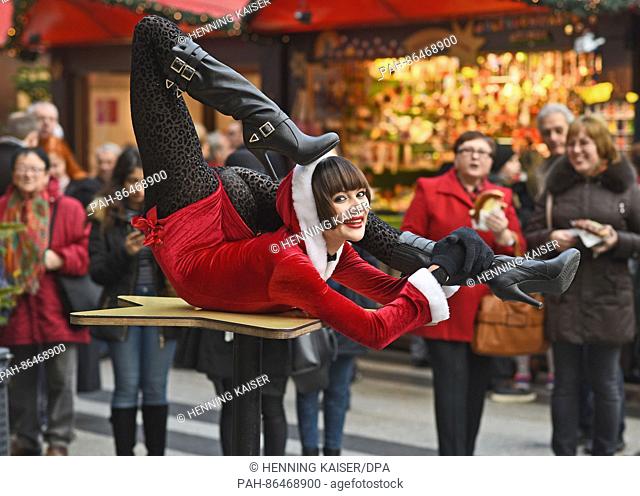 Contortionist Alina Ruppel shows off her skills on a table at the Christmas market in Cologne, Germany, 12 December 2016