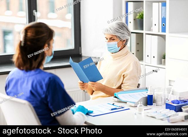 doctor and senior woman reading medical brochure