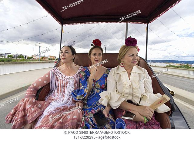 Three women in traditional andalusian costume in a car. Cordoba, Andalusia, Spain