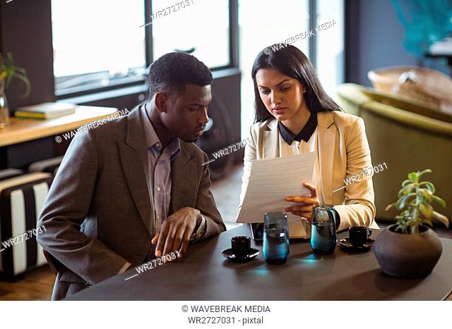 Businessman and a colleague discussing over document