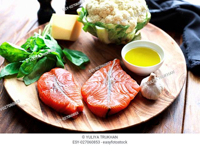 Raw humpback salmon steaks, rustic wooden background, above view. Fillet with fresh ingredients for tasty cooking and frying pan. Top view