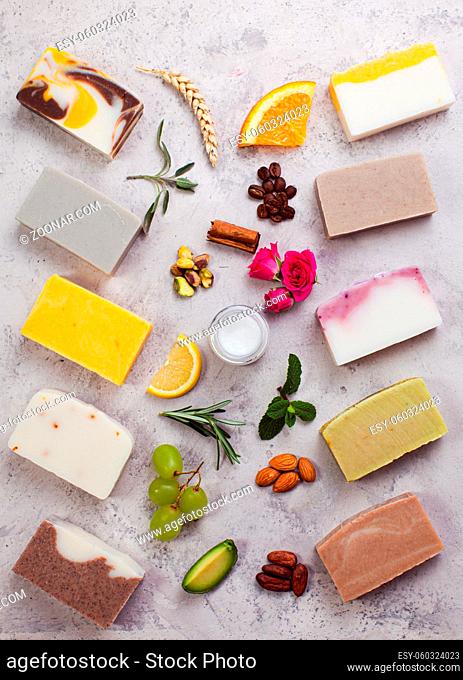 Flat lay set of different handmade soap on a light grey surface. Fresh floral soap ingredients. Organic cosmetics concept