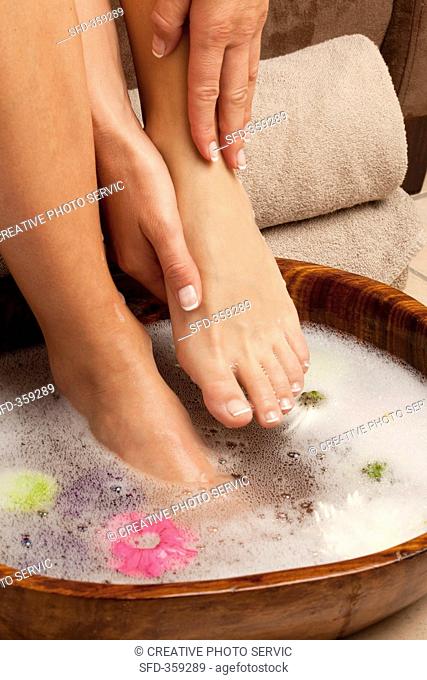 Feet in a foot bath with flower petals