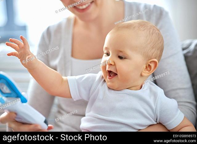 mother with baby playing with toy phone at home