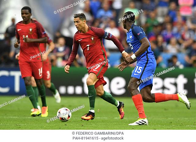 Paul Pogba (R) of France and Cristiano Ronaldo (C) of Portugal vie for the ball during the UEFA EURO 2016 soccer Final match between Portugal and France at the...
