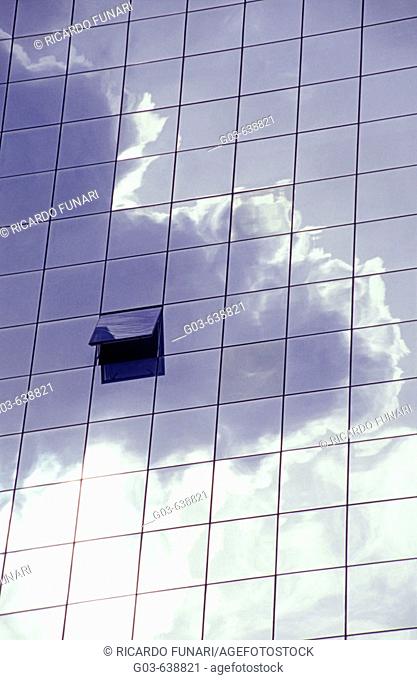 Window, modern architecture. Clouds reflected in a glass building