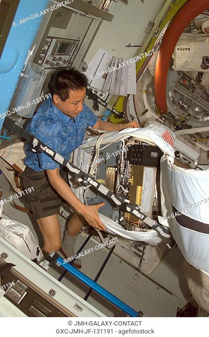 Astronaut Edward T. Lu, Expedition 7 NASA ISS science officer and flight engineer, performs routine maintenance on an Extravehicular Mobility Unit (EMU) space...