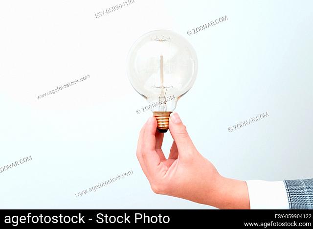 Woman Hand Holding Lamp Presenting Ideas For Project, Man Fists Showing Bulb And New Technologies, Held Lightbulb Exhibiting Another Opinion