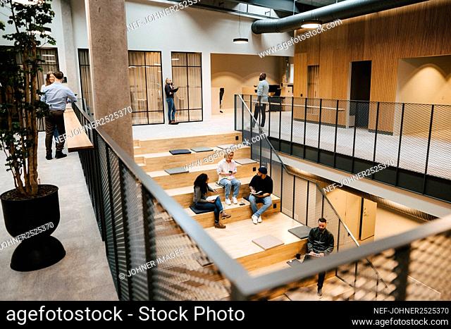 People relaxing on stairs in office building