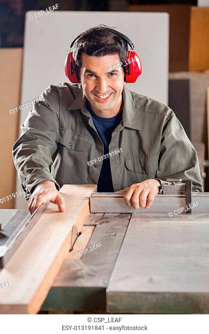 Confident Carpenter Cutting Wooden Plank With Tablesaw