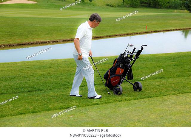 man and golf trolley