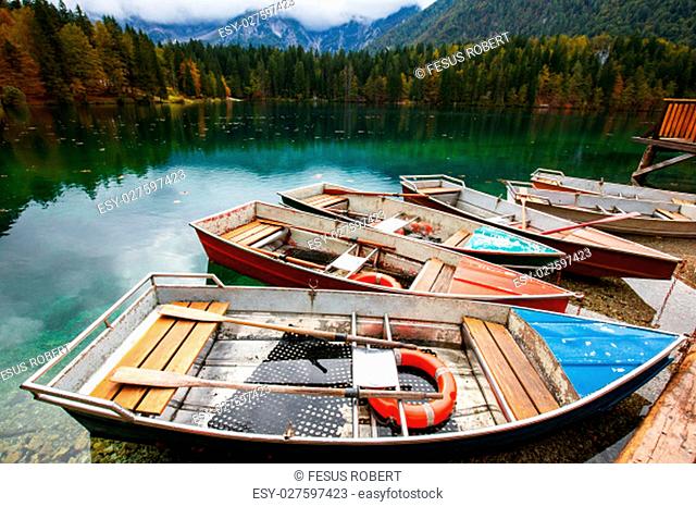 Alpine landscape and colorful boats near Slovenian-Italy border, Lake Fusine, Italy