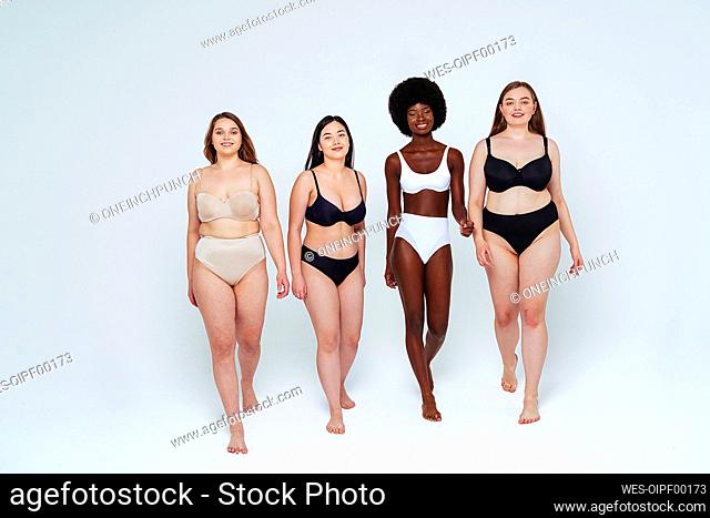 Confident young women smiling while walking in studio