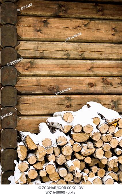 Birch fire wood at a wall of the house in winter