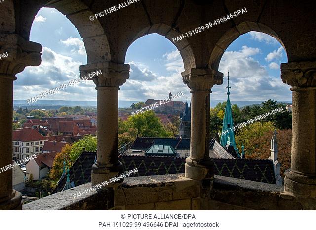 29 October 2019, Saxony-Anhalt, Quedlinburg: Clouds are moving over Quedlinburg Castle, which can be seen through the middle window of the Sternkieckerturm