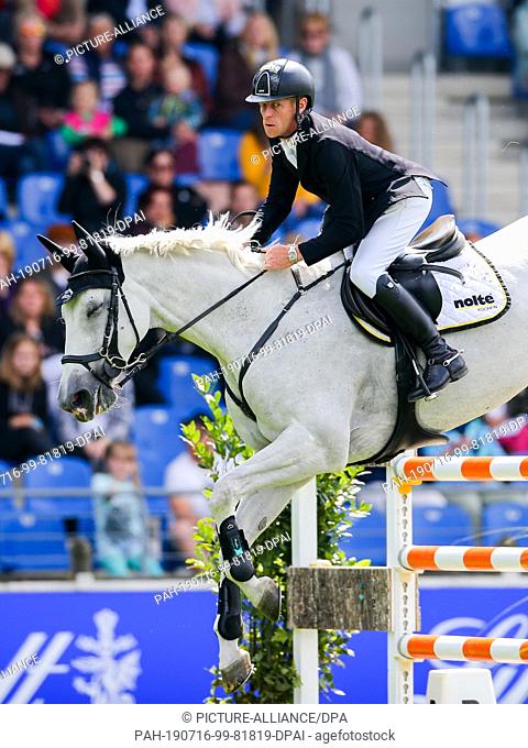 16 July 2019, North Rhine-Westphalia, Aachen: CHIO, equestrian sports, jumping: The German rider Marcus Ehning on the horse Calanda jumps over an obstacle