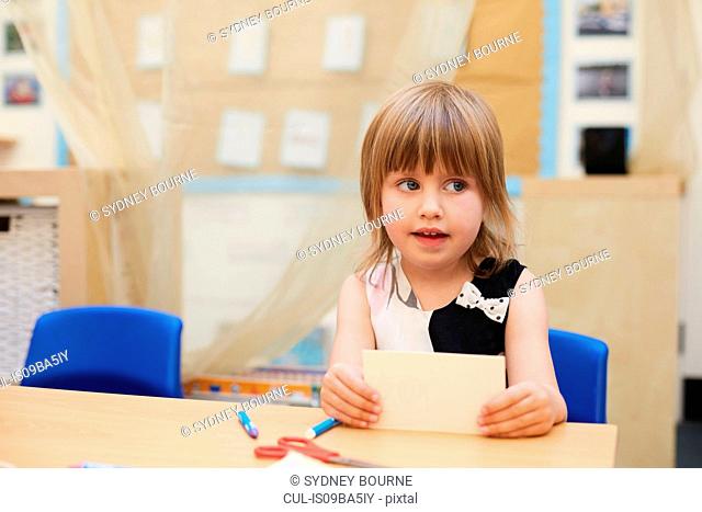 Primary schoolgirl looking sideways from classroom desk