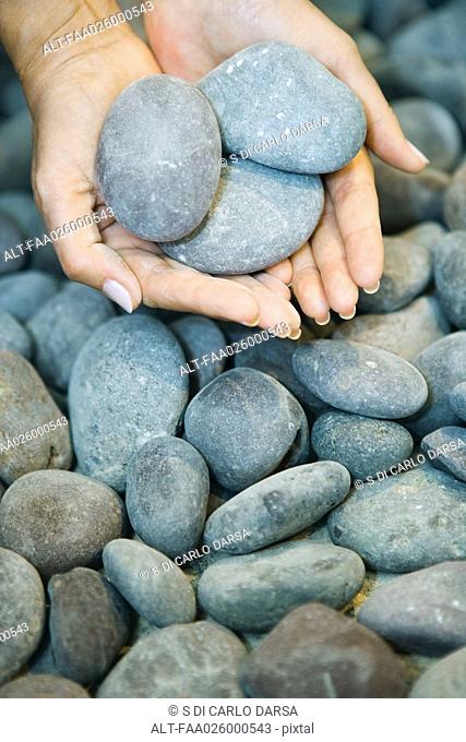 Hands holding pebbles, close-up