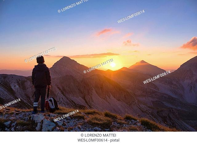 Italy, Abruzzo, Gran Sasso e Monti della Laga National Park, Portella Mountain, hiker watching sunset