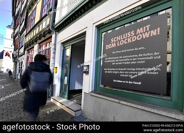 02 March 2021, Thuringia, Erfurt: ""Stop the lockdown!"" reads the poster on a shop window in the old town. Thuringia remains the state most severely affected...