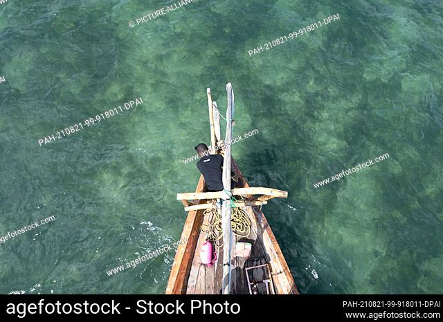 02 August 2021, Tanzania, Fumba: A fisherman weighs anchor aboard a fishing boat. Photo: Sebastian Kahnert/dpa-Zentralbild/dpa