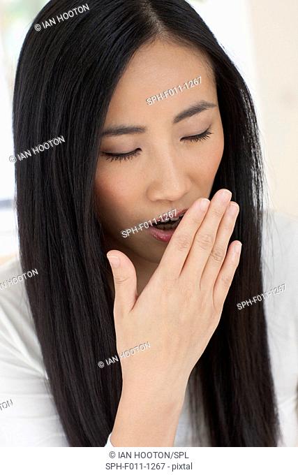 Mid adult woman yawning, portrait