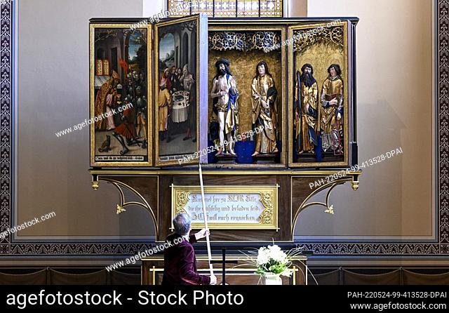 24 May 2022, Saxony-Anhalt, Köthen: District Chief Pastor Lothar Scholz opens the festival side of the late Gothic high altar in the Lutheran Church of St