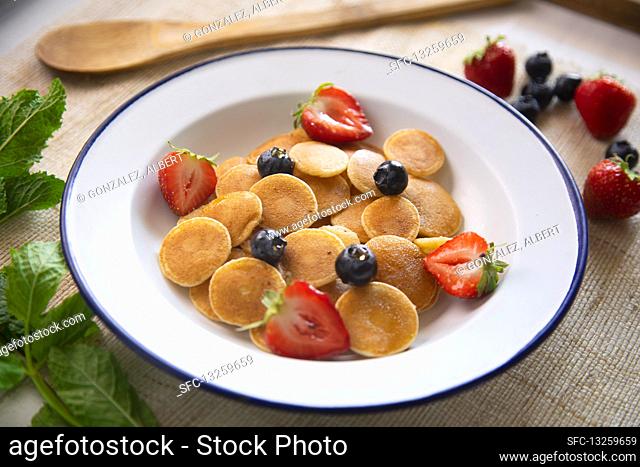 Minipancakes cereal in a bowl with milk and fruit