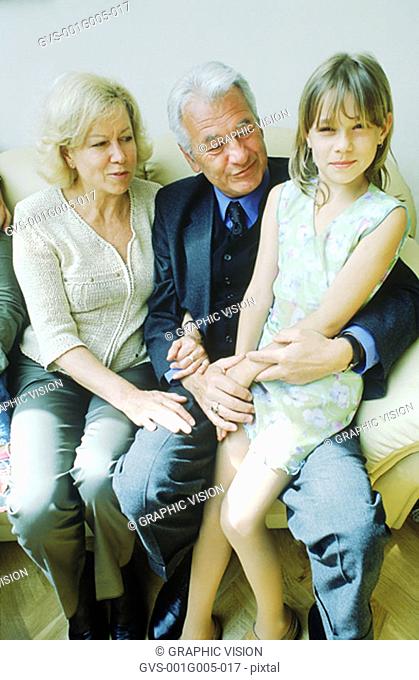 Portrait of a young girl sitting with her grandparents