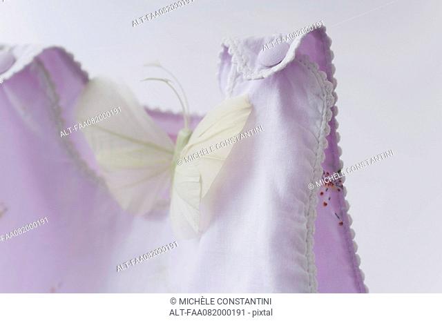 Fake butterfly resting on baby clothing