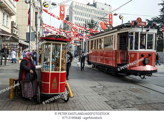 Simit bread vendor and tram in Istiklal Caddesi, Beyoglu, Istanbul, Turkey,