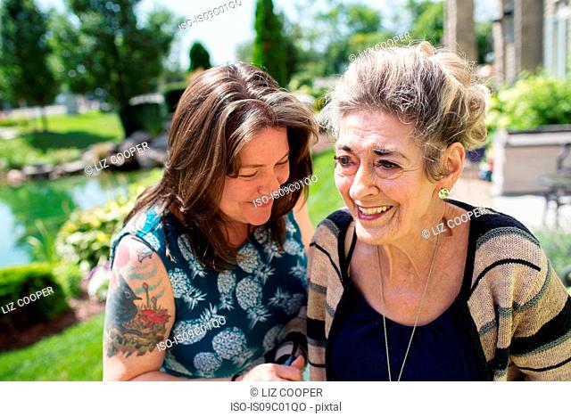 Woman laughing with her mother in garden