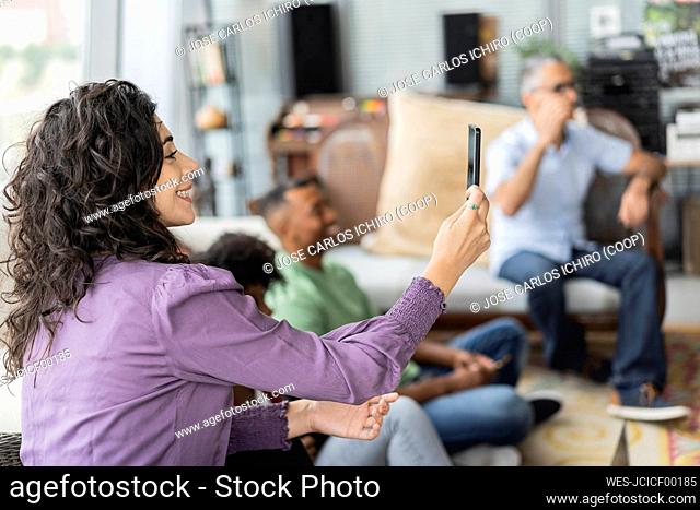Happy businesswoman filming through smart phone